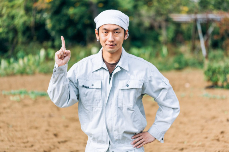 作業服で指をさす人